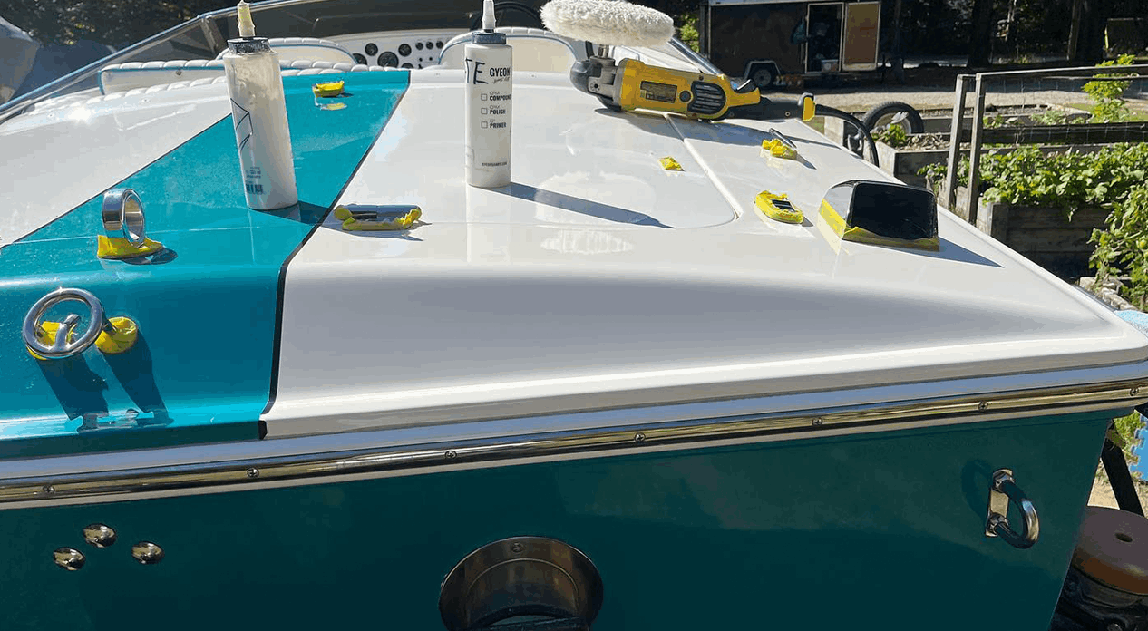 Work-in-progress shot of a blue and white boat being detailed by True North Detailing Muskoka, showing buffer tools and developing shine.