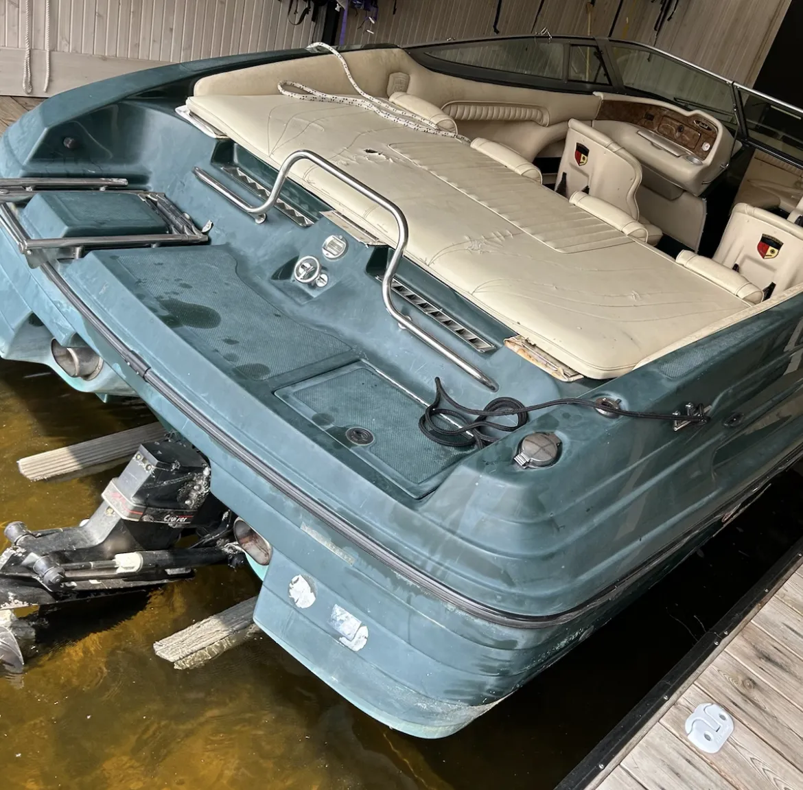 Faded teal boat with dirty cream interior and oxidized hull, showing condition before professional detailing and restoration.