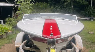 Front view of a restored white Donzi speedboat with red stripes, gleaming after True North Detailing Muskoka service.