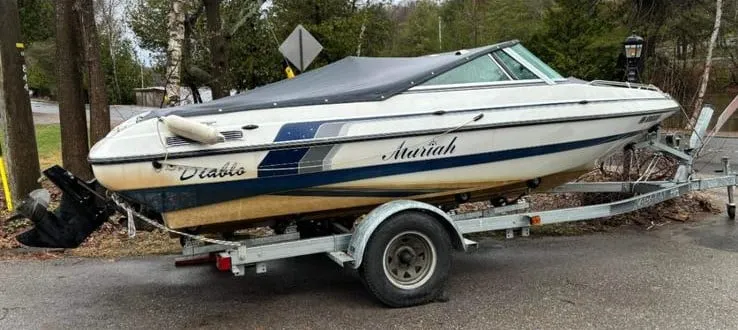 Dull and faded white and blue Mariah Diablo boat on a trailer, showing its condition before professional restoration.