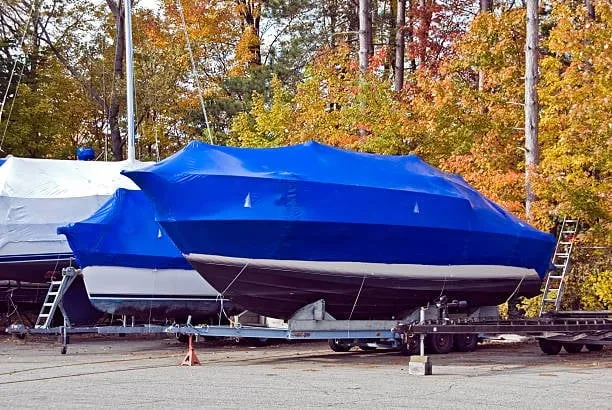 Multiple boats professionally shrink-wrapped in blue and white for winter protection by True North Detailing Muskoka.