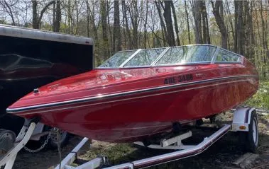 Fully restored and glossy red boat on a trailer, showcasing a vibrant, deep colour after professional detailing by True North Detailing Muskoka.