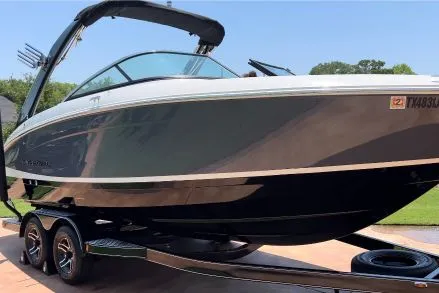 Sleek black and white Regal wake boat with a tower on a trailer, gleaming after professional detailing by True North Detailing Muskoka.