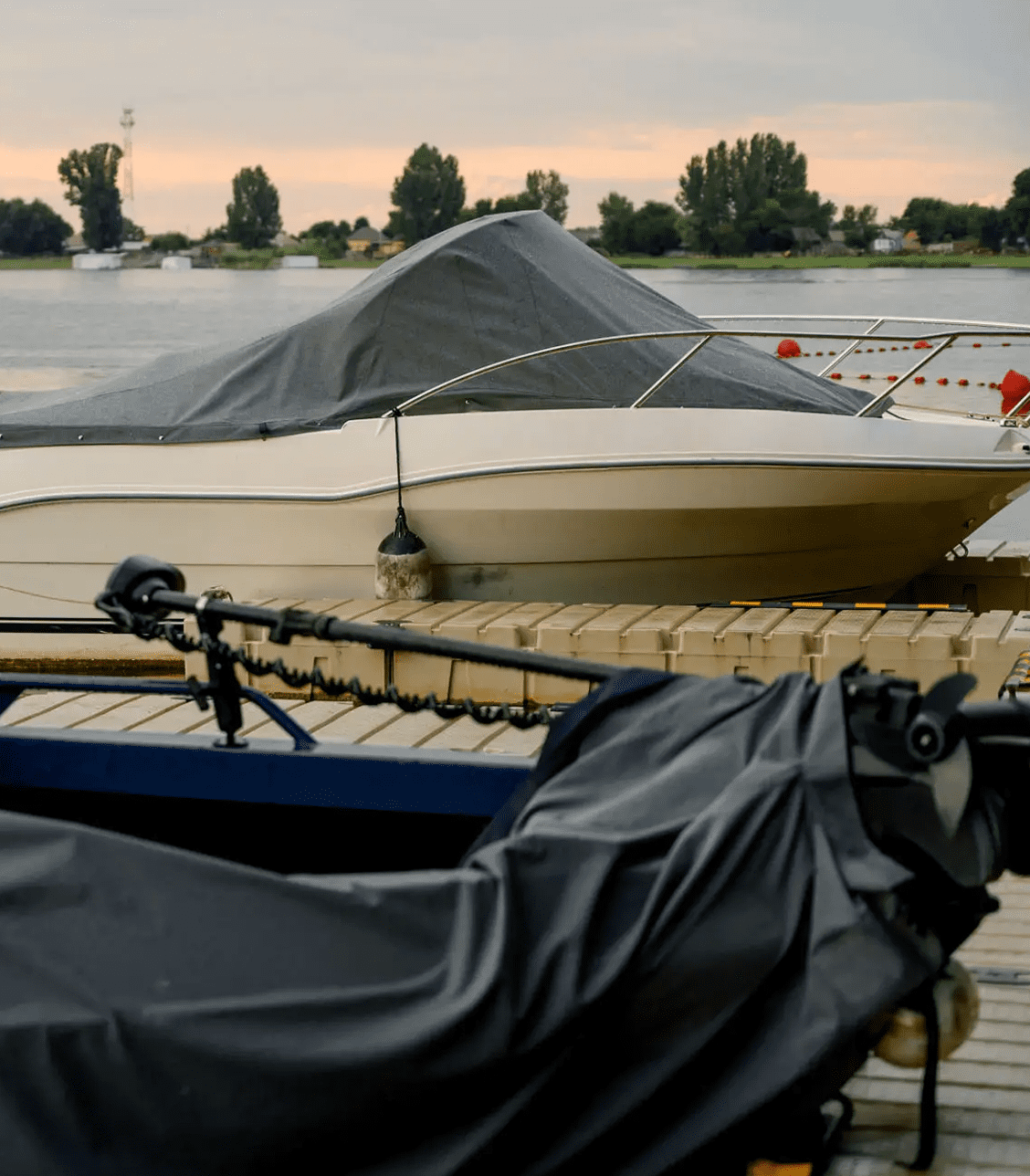 Covered boats on wooden dock at sunset