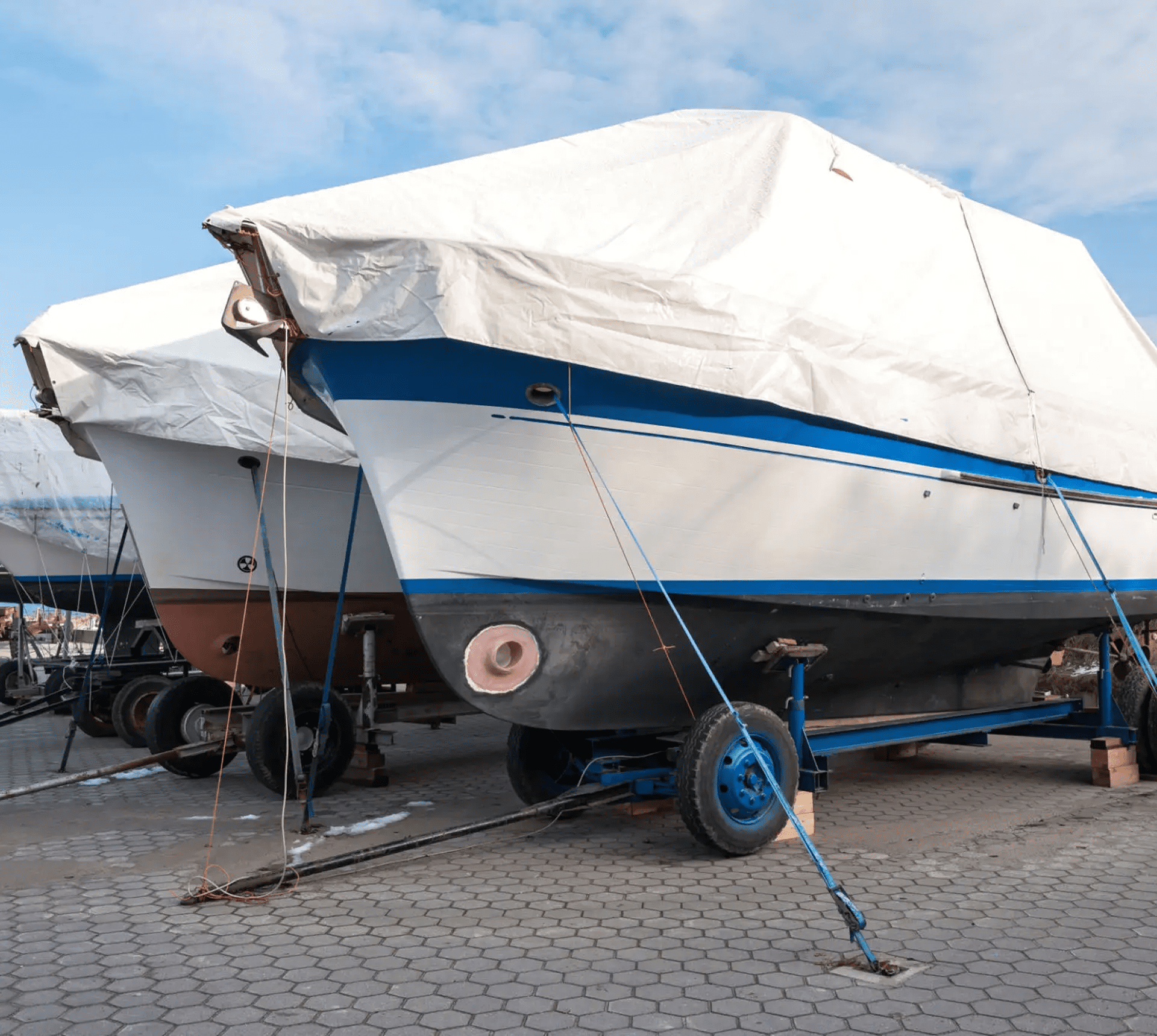 Docked boats with protective covers.